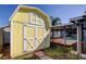 Backyard features a yellow storage shed with white doors and a screened in pool at 1612 Sunset Dr, Tarpon Springs, FL 34689