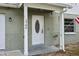 White front door with a glass oval window and brick facade at 1704 W Humphrey St, Tampa, FL 33604