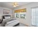 Bright bedroom with a comfortable bed, window, and ceiling fan at 224 Sky Loch E Dr, Dunedin, FL 34698