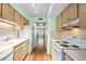 Kitchen with light wood cabinets, white appliances, and laminate floors at 224 Sky Loch E Dr, Dunedin, FL 34698
