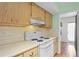 White appliances and light wood cabinets in kitchen at 224 Sky Loch E Dr, Dunedin, FL 34698