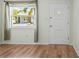 View of living room, showing a window, door and wood floors at 224 Sky Loch E Dr, Dunedin, FL 34698