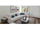 Living room with white sectional sofa, coffee table, and hardwood floors at 224 Sky Loch E Dr, Dunedin, FL 34698