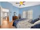 Bright bedroom with light blue walls, wood floors and a view to living room at 2852 Banyan Hill Ln, Land O Lakes, FL 34639