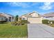Cute yellow house with well-manicured lawn and driveway at 2852 Banyan Hill Ln, Land O Lakes, FL 34639