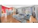 Open living space featuring hardwood floors and a red accent wall at 2852 Banyan Hill Ln, Land O Lakes, FL 34639