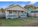 A yellow house with a porch, fenced yard, and driveway at 3436 51St N Ave, St Petersburg, FL 33714