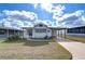 Quaint white manufactured home with a covered carport and small yard at 35216 Dodie Dr, Zephyrhills, FL 33541