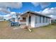 White mobile home with screened porch and landscaping at 35216 Dodie Dr, Zephyrhills, FL 33541