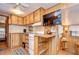 Cozy kitchen features wood cabinets, and a view into the living room at 35216 Dodie Dr, Zephyrhills, FL 33541