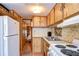 Galley-style kitchen with white appliances and wood cabinets at 35216 Dodie Dr, Zephyrhills, FL 33541