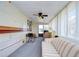 Bright sunroom with a striped couch and a wooden desk at 35216 Dodie Dr, Zephyrhills, FL 33541