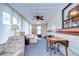 Sunroom features a striped couch, a ceiling fan, and large windows at 35216 Dodie Dr, Zephyrhills, FL 33541