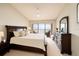Spacious bedroom with dark furniture, a comfy bed, a balcony, and a beautiful view at 7540 Sunshine Skyway S Ln # 220, St Petersburg, FL 33711