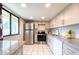 Well-lit kitchen featuring stainless steel appliances, ample white cabinetry, and granite countertops at 7540 Sunshine Skyway S Ln # 220, St Petersburg, FL 33711