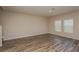 Spacious living room with wood-look flooring and large windows at 7685 Peace Lily Ave, Wesley Chapel, FL 33545