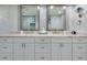 Elegant bathroom with double vanity, marble tile, and large mirrors at 8134 Bayshore Dr, Seminole, FL 33776