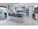 Open concept kitchen featuring a breakfast bar, stainless steel refrigerator, and view to the pool area at 8134 Bayshore Dr, Seminole, FL 33776