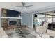 Comfortable living room with stone fireplace, tv, and sliding glass doors leading to the pool at 8134 Bayshore Dr, Seminole, FL 33776