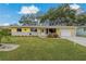 Charming yellow house with gray accents and a lush green lawn at 868 James St, Dunedin, FL 34698