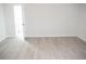 Spacious bedroom with an open doorway to a bathroom and light wood-look flooring at 11300 Yellowwood Ln, Port Richey, FL 34668