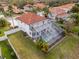 Aerial view of a home with a red tile roof, a screened-in pool, and a well-maintained backyard at 22847 Sonoma Ln, Lutz, FL 33549