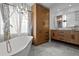 A luxurious bathroom featuring dual sink vanity, a soaking tub, a custom armoire, and modern finishes throughout at 22847 Sonoma Ln, Lutz, FL 33549