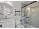 Charming bathroom with a glass shower, a round mirror, and a modern vanity and toilet at 22847 Sonoma Ln, Lutz, FL 33549
