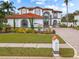 Charming two-story house boasts a red-tiled roof, manicured lawn, and colorful flower beds at 22847 Sonoma Ln, Lutz, FL 33549