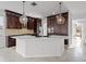 Gourmet kitchen featuring dark wood cabinets, stainless appliances, quartz countertops, and a center island at 22847 Sonoma Ln, Lutz, FL 33549