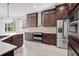 Modern kitchen with stainless steel appliances, dark wood cabinetry, and white countertops at 22847 Sonoma Ln, Lutz, FL 33549