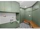 Well-organized laundry room with green cabinetry, stylish patterned floor, and ample storage space at 22847 Sonoma Ln, Lutz, FL 33549