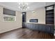 Cozy living room featuring custom built-ins, an electric fireplace, and a large window at 22847 Sonoma Ln, Lutz, FL 33549