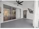 Covered outdoor patio with sliding glass doors, a ceiling fan, and a mounted TV for entertainment at 22847 Sonoma Ln, Lutz, FL 33549
