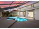 Screened-in pool area with a uniquely shaped pool, a covered patio, and an upper-level balcony at 22847 Sonoma Ln, Lutz, FL 33549