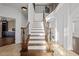 Elegant staircase featuring a wood and white design with decorative metal railings leading to the upper level at 22847 Sonoma Ln, Lutz, FL 33549