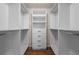 Spacious walk-in closet with custom white shelving, drawers and hanging space for optimal storage and organization at 22847 Sonoma Ln, Lutz, FL 33549