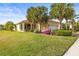 One-story house with a landscaped yard, palm trees, and a two-car garage at 4817 Sandy Glen Way, Wimauma, FL 33598