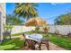 Charming backyard with patio, table, chairs, and umbrella at 4943 Grand Oak Cir, Madeira Beach, FL 33708