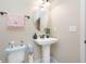 Powder room with pedestal sink and decorative accents at 4943 Grand Oak Cir, Madeira Beach, FL 33708