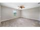 Empty bedroom with plush carpeting, a ceiling fan, and a large window at 4943 Grand Oak Cir, Madeira Beach, FL 33708