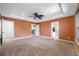 Large bedroom featuring a tray ceiling, ceiling fan, carpet flooring, and access to the bathroom and hallway at 4943 Grand Oak Cir, Madeira Beach, FL 33708