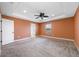 Spacious bedroom featuring a tray ceiling, ceiling fan, carpet floors, and a private door at 4943 Grand Oak Cir, Madeira Beach, FL 33708