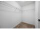 A walk-in closet with carpeted floors and built-in shelving for storage at 4943 Grand Oak Cir, Madeira Beach, FL 33708