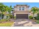 Two-story house with brown garage door, landscaping, and brick paver driveway at 4943 Grand Oak Cir, Madeira Beach, FL 33708