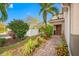 Landscaped front yard with brick walkway leading to house entrance at 4943 Grand Oak Cir, Madeira Beach, FL 33708