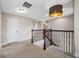 Second floor hallway showcasing wood and iron railing, neutral paint, and decorative light fixture hanging from the ceiling at 4943 Grand Oak Cir, Madeira Beach, FL 33708