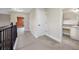 Upstairs hallway featuring neutral walls, carpet flooring, wood railing and trim, and bathroom and bedroom entrances at 4943 Grand Oak Cir, Madeira Beach, FL 33708
