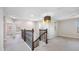 Hallway area featuring wood railing, neutral paint and a decorative ceiling light fixture at 4943 Grand Oak Cir, Madeira Beach, FL 33708