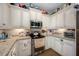 Kitchen boasts stainless steel appliances, granite counters, and ample white cabinetry at 4943 Grand Oak Cir, Madeira Beach, FL 33708